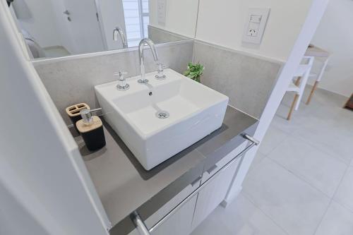 a bathroom with a white sink and a mirror at Dpto Belgrano II - Santa Fe in Santa Fe