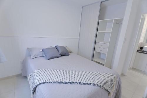 a white bedroom with a bed and a mirror at Dpto Belgrano II - Santa Fe in Santa Fe