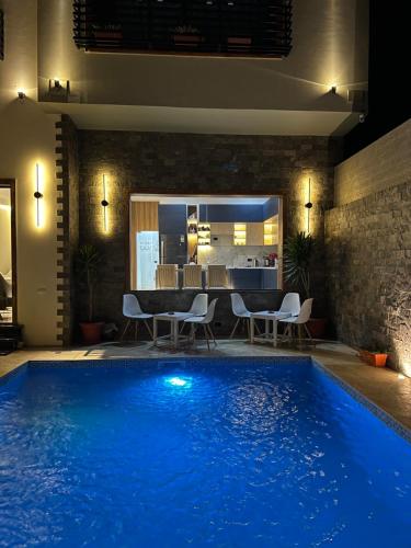a large blue swimming pool in a room with a kitchen at Farida Habu Palace Hotel luxor in Al Aqālitah