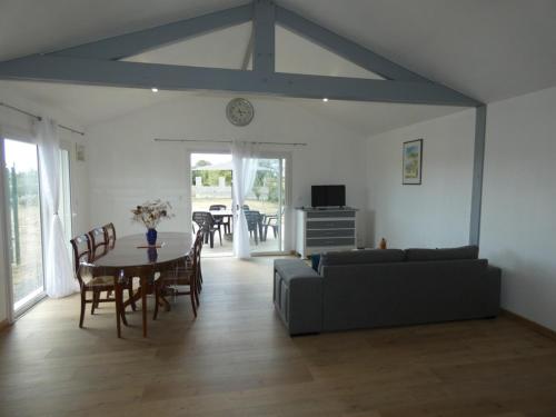 un salon avec une table et un canapé dans l'établissement Maison 94m² rénovée, 4 personnes, animaux admis, jardin - FR-1-540-311, à Notre-Dame-de-Monts