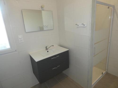 une salle de bain blanche avec un lavabo et un miroir dans l'établissement Maison 94m² rénovée, 4 personnes, animaux admis, jardin - FR-1-540-311, à Notre-Dame-de-Monts