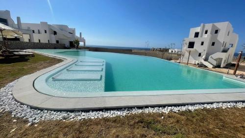 a large swimming pool in front of some buildings at Jefaira Senior Chalet, 4 bedrooms with roof in Jalāl