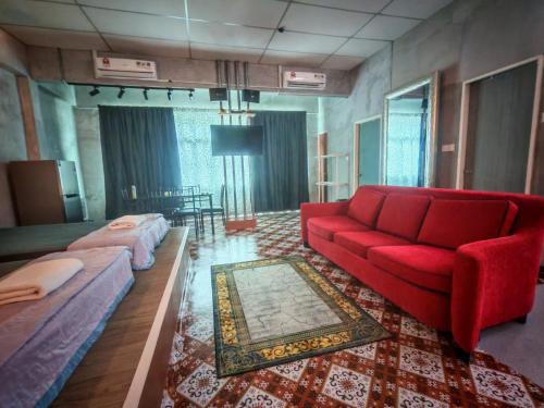 a living room with a red couch and a bed at Defaso Homestay Kota Marudu in Kampong Karungkon