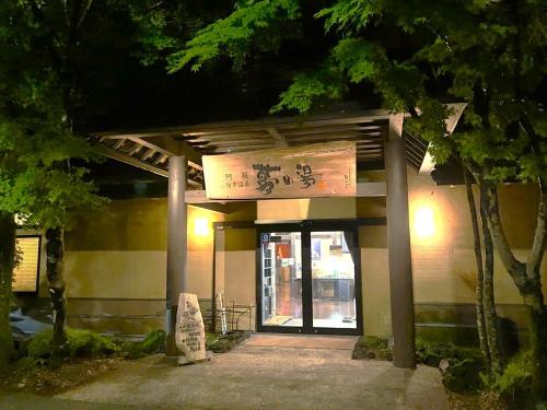a building with a sign in front of it at ホテルトレーラーシップガーデン阿蘇 in Aso
