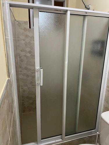 a shower with a glass door in a bathroom at Clora Hotel 