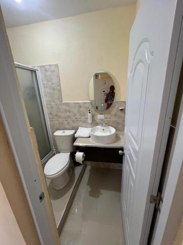 a bathroom with a toilet and a sink and a mirror at Clora Hotel 