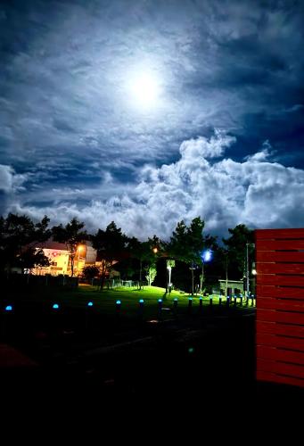 a view of a park at night with the moon at ホテルトレーラーシップガーデン阿蘇 in Aso