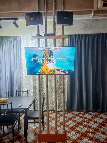 a screen on a stand in a room with a table at Defaso Homestay Kota Marudu in Kampong Karungkon