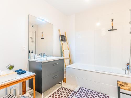 a bathroom with a bath tub and a sink and a bath tub at Appartement T3 Moderne avec Terrasse, 2 Parkings, Proche Centre – 4 Personnes, 2 Étoiles - FR-1-521-215 in Sanguinet