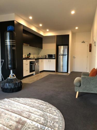 a large living room with a kitchen and a couch at Entire apartment with washer-dryer machine near Footscray in Melbourne
