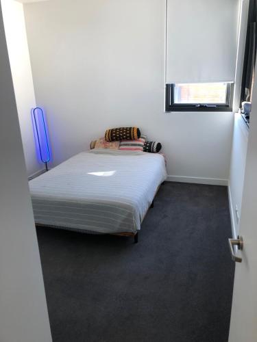a small white room with a bed in it at Entire apartment with washer-dryer machine near Footscray in Melbourne