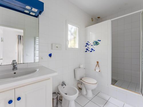 ein weißes Badezimmer mit Toilette und Waschbecken in der Unterkunft Villa avec piscine privée, jardin clôturé et WIFI à Biscarrosse - Idéale pour 6 personnes - FR-1-521-192 in Biscarrosse