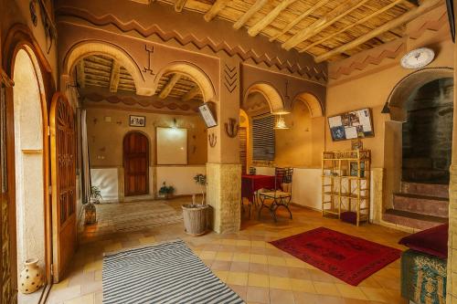 a living room with a large room with a fireplace at Auberge La Fibule Du Dades in Aït Idaïr