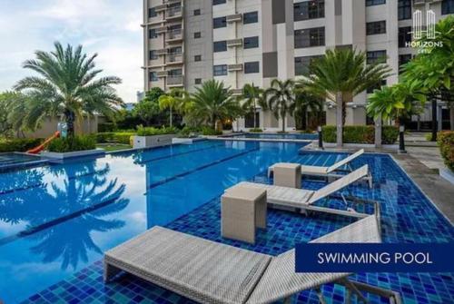 une piscine dans un complexe hôtelier avec des palmiers dans l'établissement Cebu - HORIZON 101 CONDO RENTAL, à Cebu