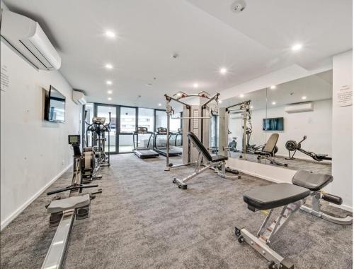 a gym with several treadmills and exercise machines at New High Floor Apartment in the heart of Canberra in Canberra