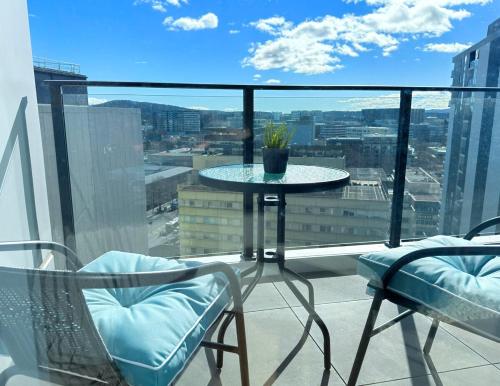 a table and chairs on a balcony with a view at New High Floor Apartment in the heart of Canberra in Canberra