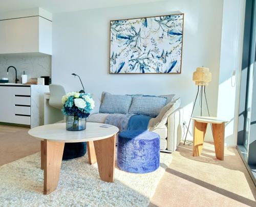 a living room with a table and a couch at New High Floor Apartment in the heart of Canberra in Canberra