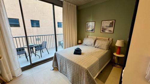 サンパウロにあるDM 405 Contemporâneo apto prox ao metrô V Marianaのベッドと大きな窓のある寝室