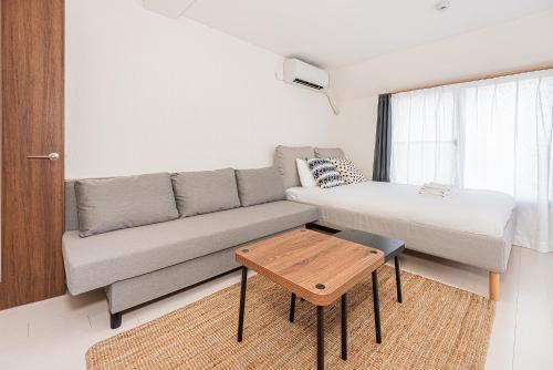 una pequeña sala de estar con sofá y cama en 67Apt Shinkoiwa, en Tokio