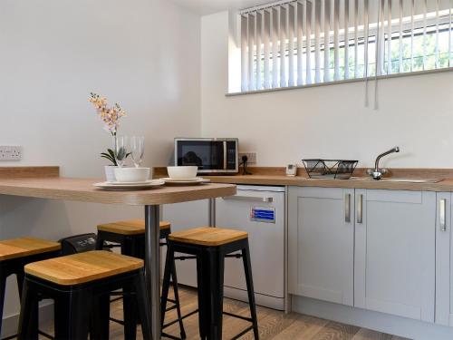 a kitchen with a table with stools and a microwave at Elm - Uk11991 in Greenhill
