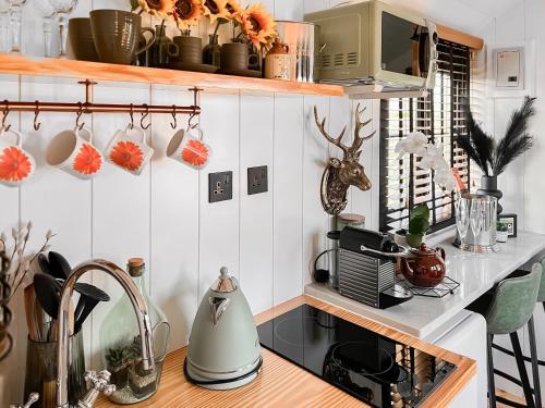 a kitchen with white tiled walls and a counter at Herdwick in Grove