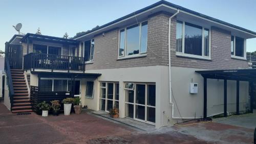 a large house with a balcony and a staircase at Charming Room in Wellingtons Coastal Heart in Wellington