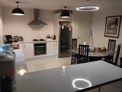 a kitchen with a table and chairs and a refrigerator at Charming Room in Wellingtons Coastal Heart in Wellington
