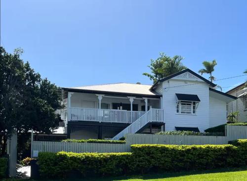 a white house with a fence in front of it at Private Garden Suite in Classic Queenslander - Near CBD and Royal Brisbane Hospital in Brisbane