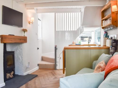 a living room with a couch and a fireplace at The Wee Cottage in Polperro
