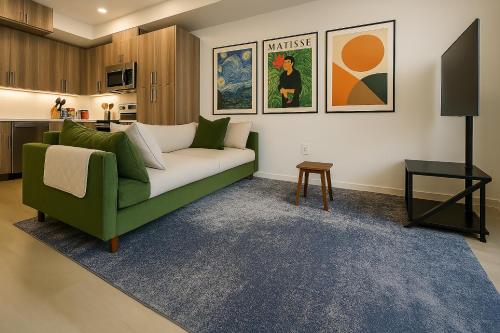 a living room with a green couch and a table at Zen Den at Ciph Lab, Eco-Tech, Private Room, Direct BART Access to SF in Oakland