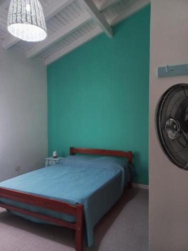 a bedroom with a bed with blue walls and a fan at La Grutas Casa de Mar in Las Grutas