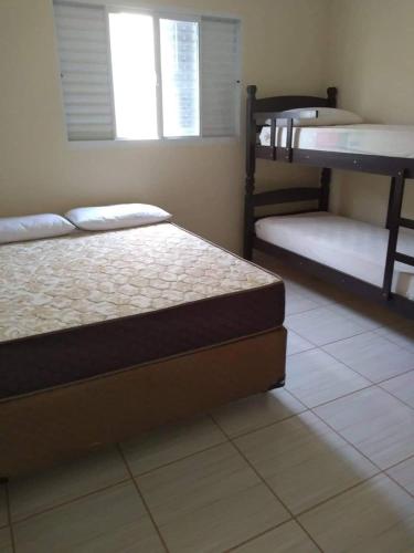 a bedroom with two beds and a window at Recanto Julia in Olímpia