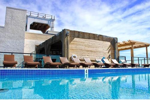 a swimming pool with chairs next to a building at XL Studio - Chic Flat - Rooftop Pool & Gym in Philadelphia