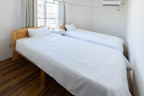 Postel nebo postele na pokoji v ubytování 潤 伊藤ビル
