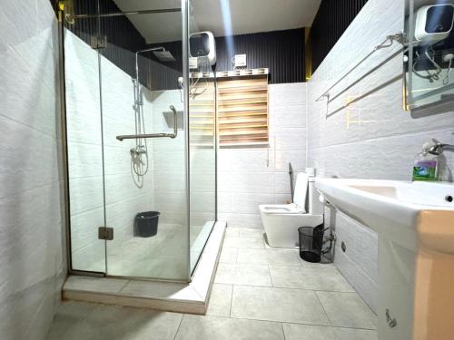 Un baño con ducha, lavabo e inodoro. en Adebisi, en Lekki