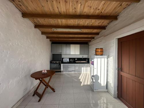 a kitchen with a table and a refrigerator at Casa de campo relax y piscina in Cerro Azul
