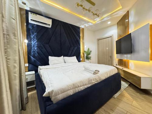 Un dormitorio con una cama grande y un televisor. en Adebisi, en Lekki