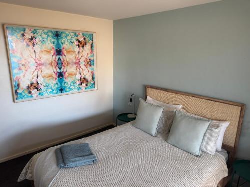 a bedroom with a bed with a painting on the wall at Sea Breeze with City Ease in Port Lincoln