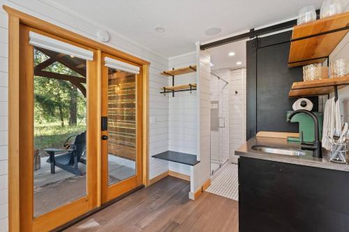 a kitchen with a sink and a sliding glass door at Eco Friendly Tiny Container Home Retreat in Camas