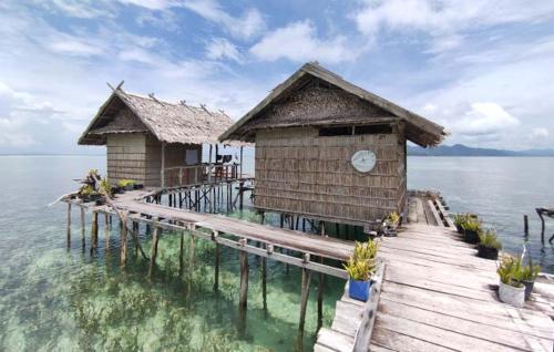 two huts on a pier in the water at Homestay Yenbeyar Raja Ampat in Yariffi