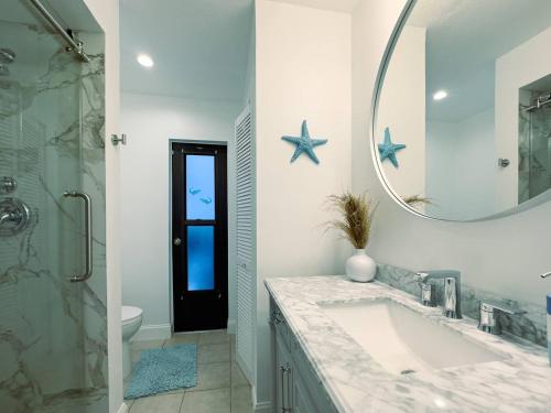 a bathroom with a sink and a mirror at House With A Boat - Boat, Heated Pool, Fishing in Cape Coral Hospital Heliport