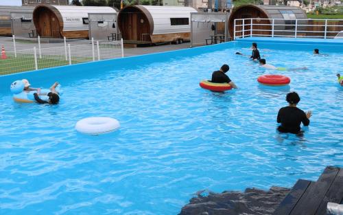 a group of people in a swimming pool with frisbees at Camp Village Geoje in Geoje 