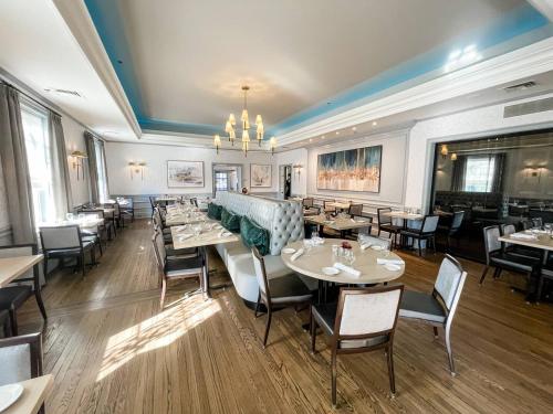 a restaurant with tables and chairs and a chandelier at Villa Signor in Norwich