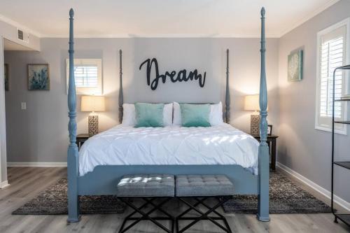 a bedroom with a blue bed with a dream sign above it at Villa Signor in Norwich