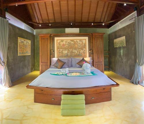 a bedroom with a large bed in a room at Maso Christian Villa in Tumbak Bayuh