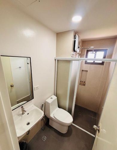 a bathroom with a toilet and a sink at Minimalist Comfort Modern Stay Cozy Vibes in Iloilo City