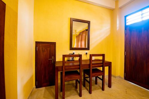 a dining room table with two chairs and a mirror at Traveller's Villa in Hatton