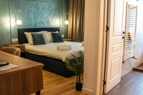 a bedroom with a bed and a desk and a door at Volotel SkyWay in Cluj-Napoca