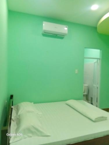 a bed in a room with a blue wall at HOTEL MOTeL Đồng Khởi in Giồng Tú Ðiền
