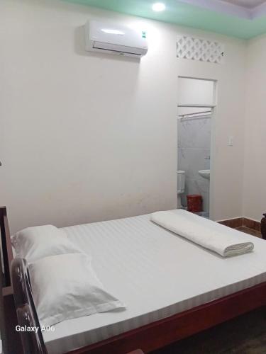 a bed in a room with a white bedsheet at HOTEL MOTeL Đồng Khởi in Giồng Tú Ðiền